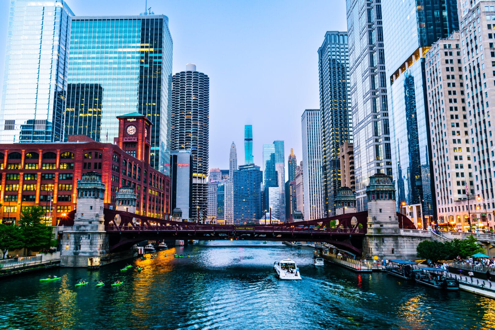 Illuminated Chicago Riverwalk and Skyscrapers at dusk.