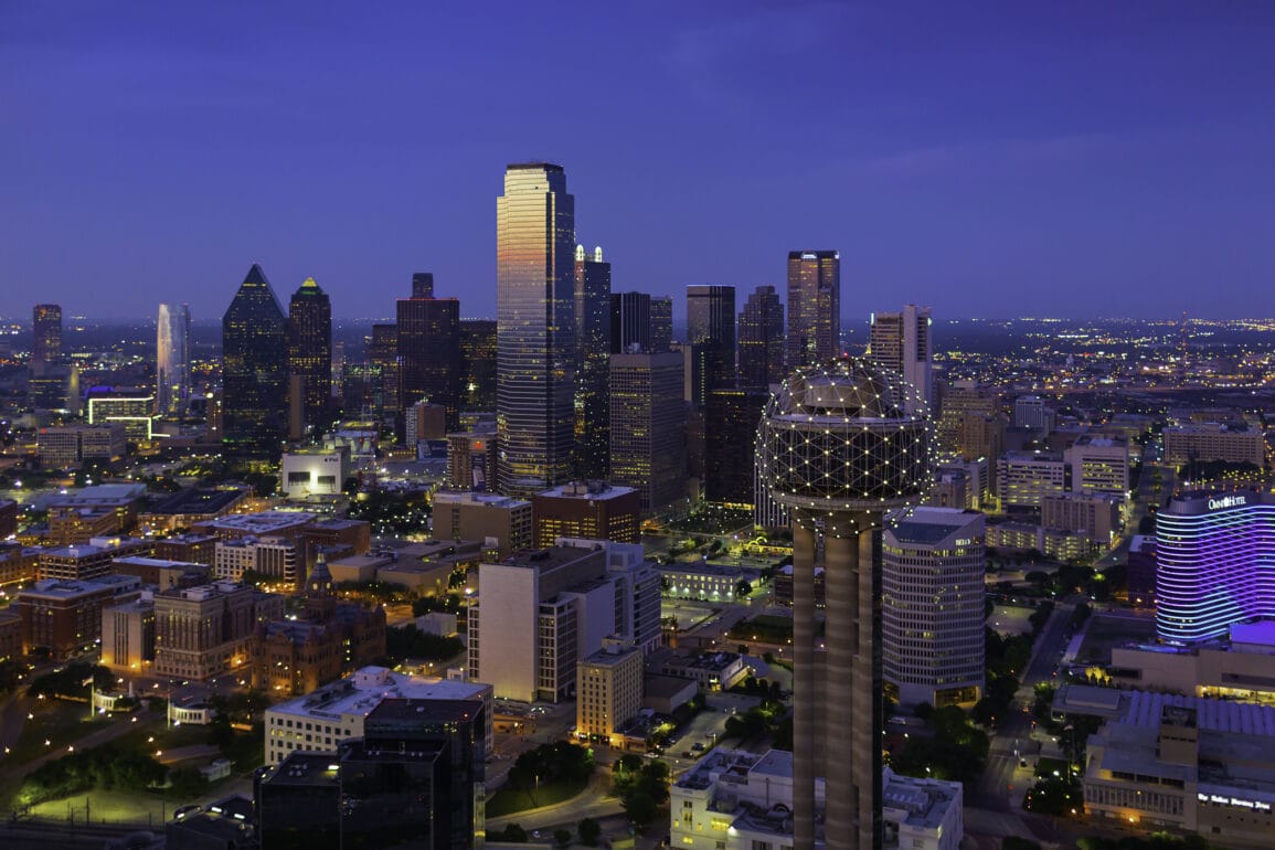 Illuminated Dallas Texas skyline at dusk.
